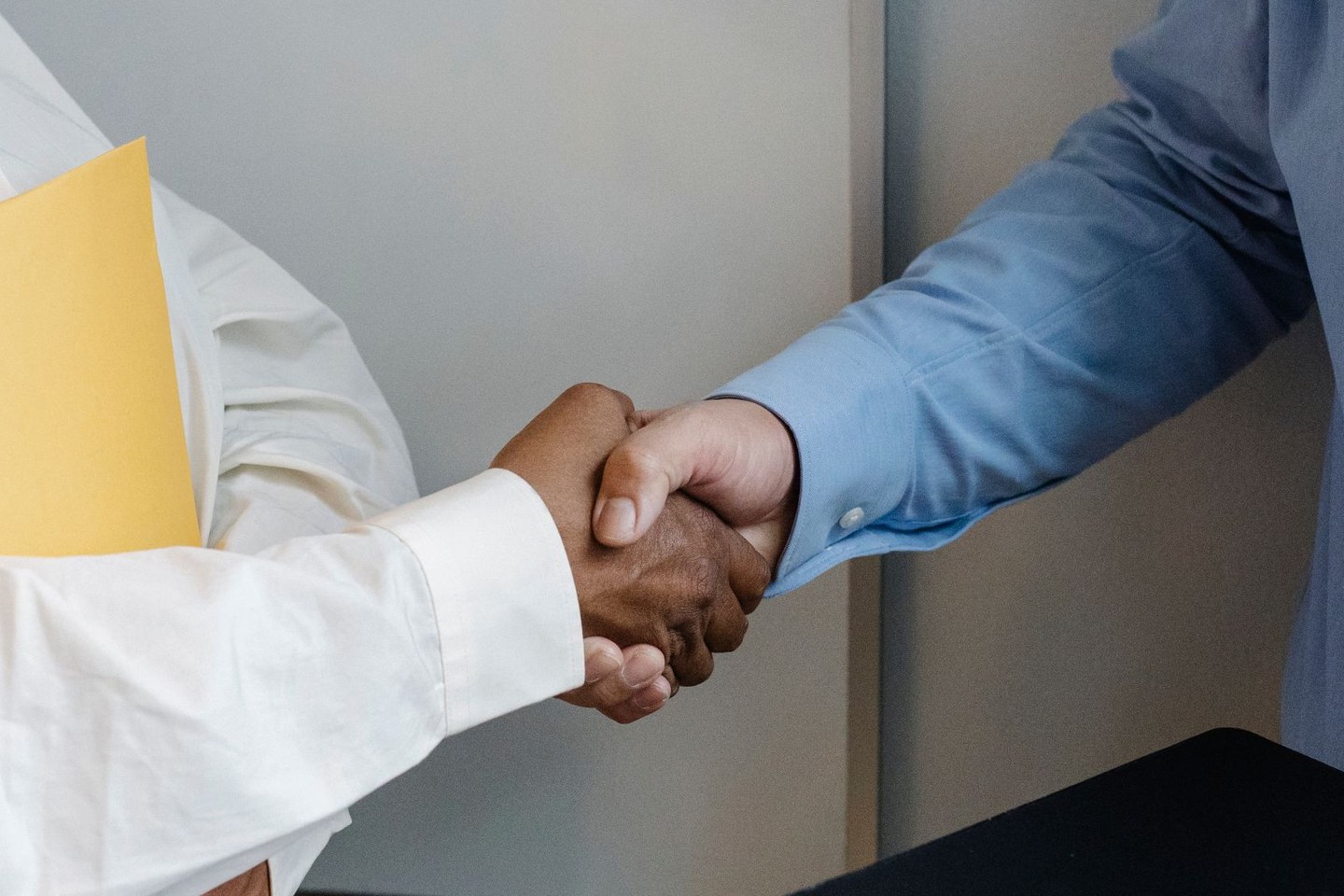 Shaking hands over contract documents after a wholesale deal is assigned