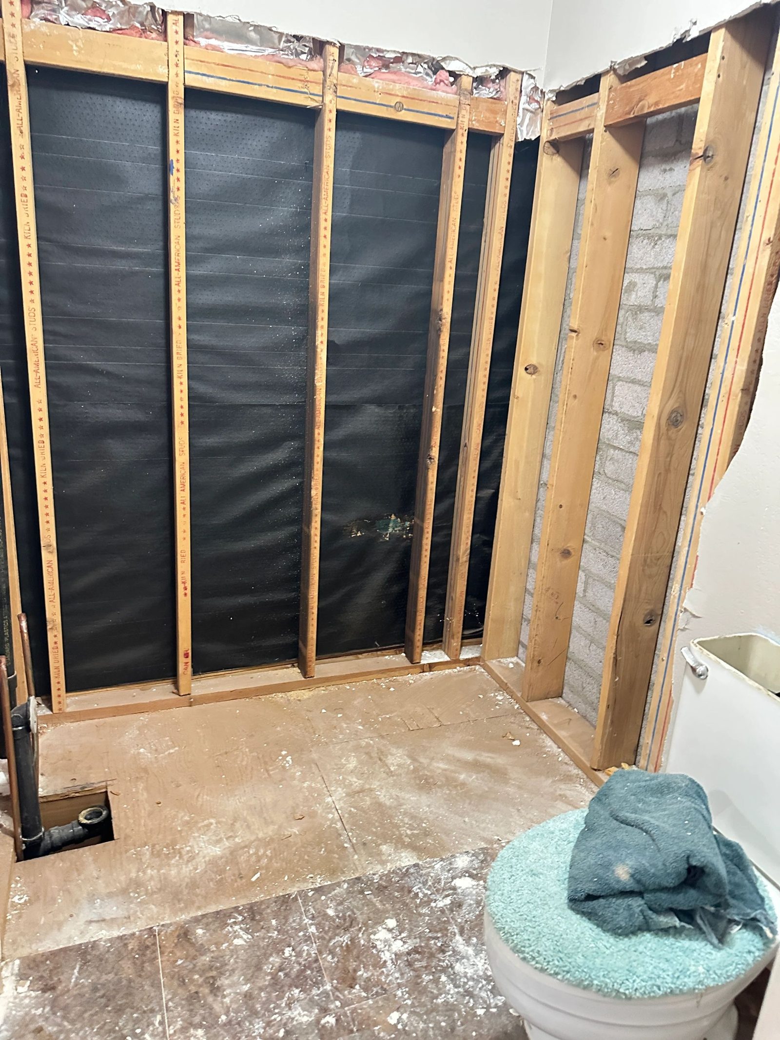 Framing and waterproofing in progress during a bathroom renovation